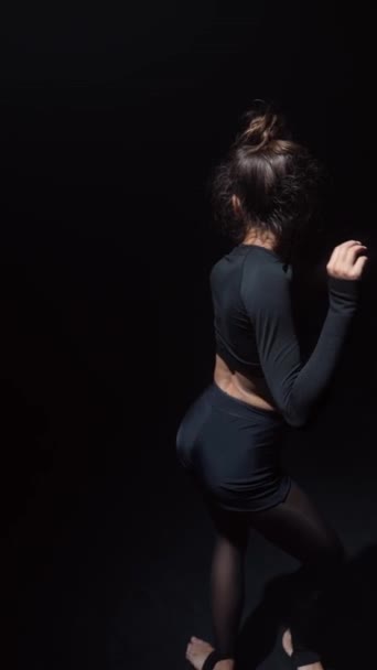 La chica, vestida de negro, está realizando una danza contemporánea. Imágenes de alta calidad 4k - Metraje, vídeo