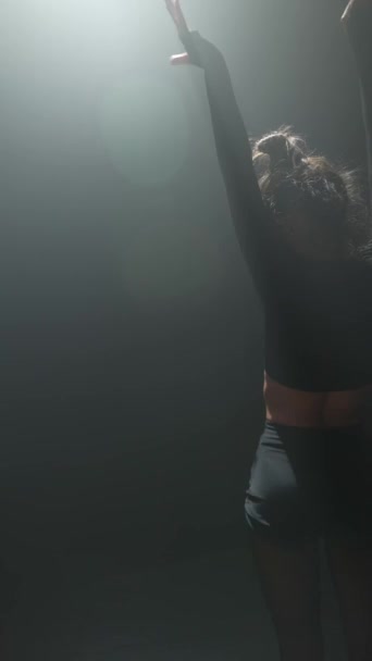 Salaperäinen nuori nainen tanssii nykyajan teosta puolipimeässä. Laadukas 4k kuvamateriaalia - Materiaali, video