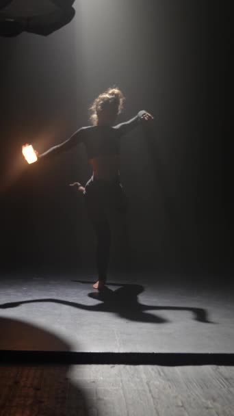 Młoda tancerka, zaangażowana we współczesną choreografię, jest w pół-ciemnym studiu. Wysokiej jakości materiał 4k - Materiał filmowy, wideo