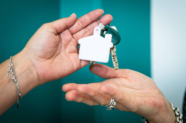 kaksi kättä vaihtavat avainta talon ostamisen jälkeen - Valokuva, kuva
