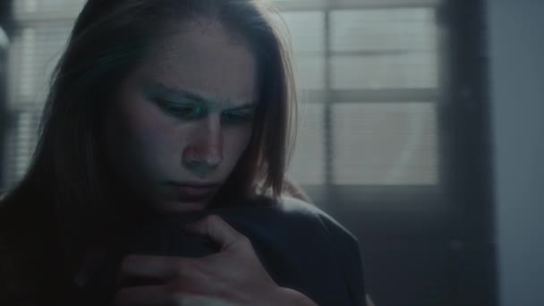 Mladá dívka čte ponižující zprávu po telefonu, objímají kolena, pláče a cítí depresi v temném pokoji během bezesné noci - Záběry, video