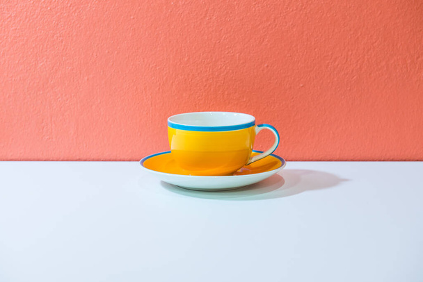 Yellow coffee cup with orange wall, Thailand. - Photo, Image