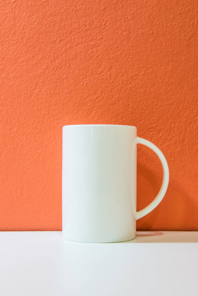 White ceramic cup with orange wall and white floor, Thailand. - Photo, Image