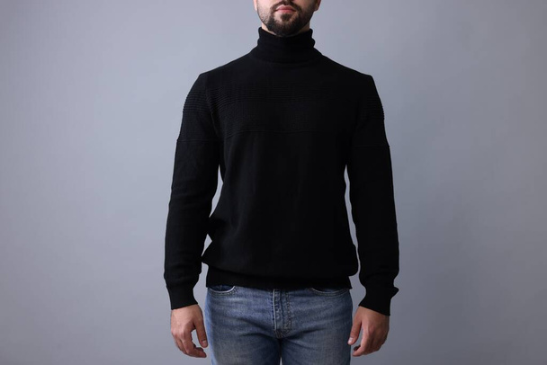 Man in stylish black sweater on grey background, closeup - Foto, imagen