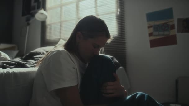 Melancholiek meisje zit op de vloer in de slaapkamer, knuffelen haar knie en huilen terwijl het hebben van depressie - Video