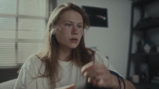 Meisje dat sms 't, telefoon weggooit en hoofd in de hand houdt terwijl ze een emotionele inzinking heeft in de slaapkamer thuis - Video