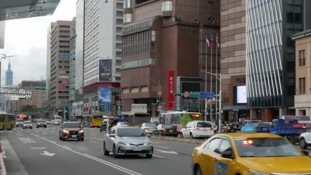7月26,2023.Taipei,台湾.高層ビルと晴れた日の下で道路上の多くのトラフィックと台北の街路の道路ビュー - 映像、動画