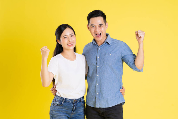 изображение азиатской пары, позирующей на желтом фоне - Фото, изображение