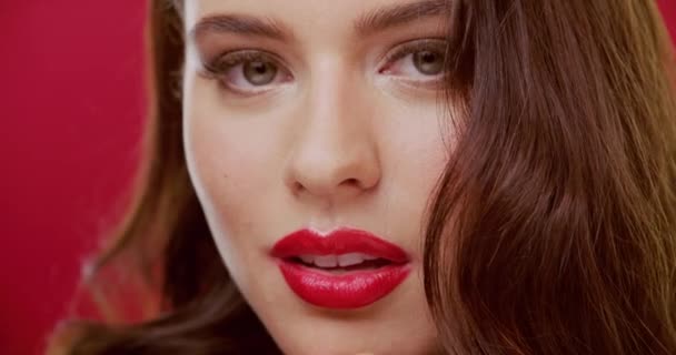 Face, red lips and woman with a smile, makeup and cosmetics on a studio background. Portrait, person and model with luxury, skincare and elegant with shine, glowing and dermatology with happiness. - Footage, Video