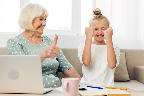 Lapsenlapsi yhdessä t-paita lapsi laptop valkoinen perhe isoäiti liimaus halaus sisätiloissa hymyilevä tila valokuvaus sohva selfie video koulutus kopioi puhelun - Valokuva, kuva