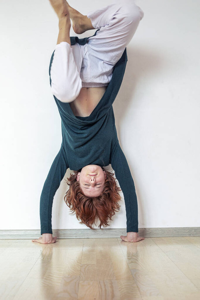 chica practicando haciendo un handstand cerca de la pared en su habitación - Foto, imagen