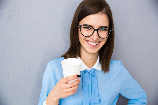 Smiling businesswoman holding cup with coffee  - Zdjęcie, obraz