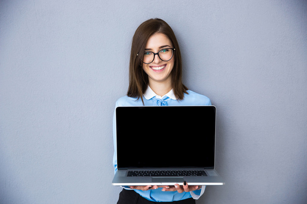 Happy businesswoman showing blank laptop screen - 写真・画像