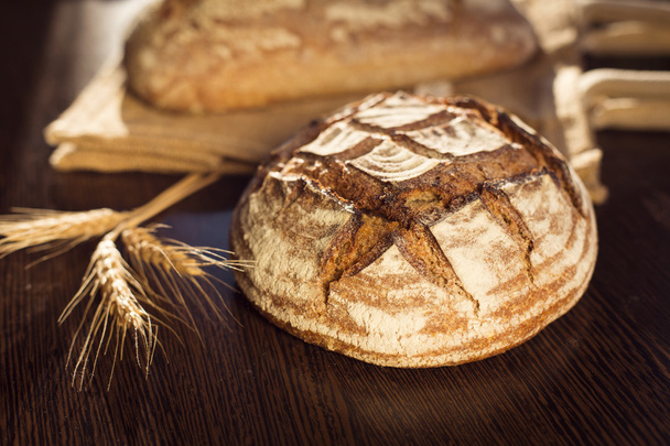 Rustic bread and wheat on a traditional cloth bag - Фото, изображение