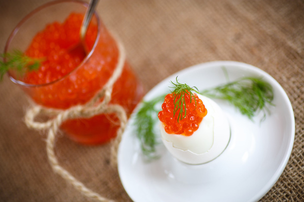 boiled egg with red caviar  - Foto, afbeelding