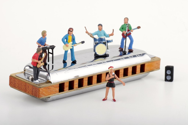 Miniatura de una banda de rock actuando en una gran armónica
 - Foto, imagen