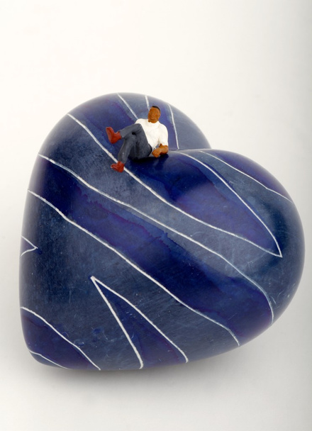 Miniature of a lonely man sitting on the top of an heart-shaped stone - Photo, Image