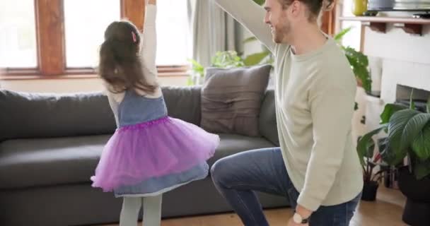 Perhe, onnellinen isä ja tyttö tanssivat olohuoneessa ystävystyäkseen, laatuaikaa ja tanssia kotona. Onnellisuus, leikkisä ja isä spin tytär hauskaa, oppiminen ja opetus liikkua rakastava side. - Materiaali, video
