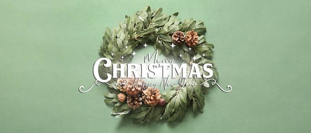Όμορφο πανό χαιρετισμού με στεφάνι Χριστουγέννων σε πράσινο φόντο - Φωτογραφία, εικόνα
