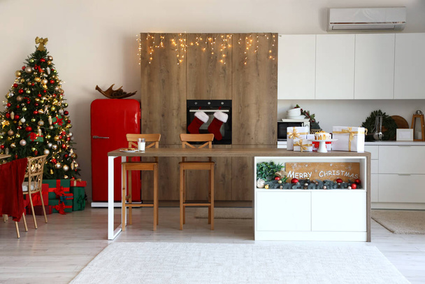 Interior da cozinha com árvore de Natal brilhante e mesa de jantar - Foto, Imagem