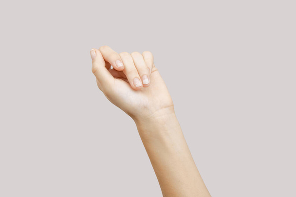 Nehty s onycholýzou po odstranění gelu leštidla na šedém pozadí. Žena ruka s poškozenými nehty s kopírovacím prostorem - Fotografie, Obrázek