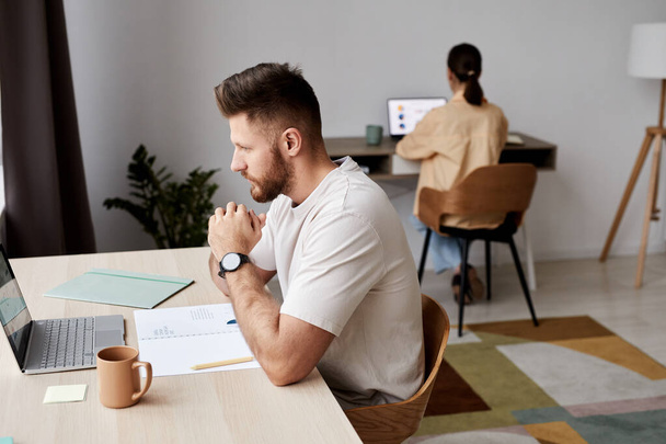 Zijaanzicht van serieuze student of freelancer zittend voor laptop per werkplek en kijkend naar scherm tijdens online les - Foto, afbeelding