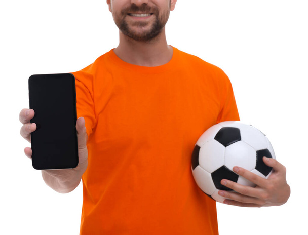 Sports fan with ball and smartphone on white background, closeup - Fotó, kép