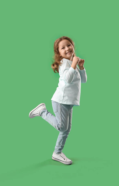 Klein meisje met pillen op groene achtergrond - Foto, afbeelding