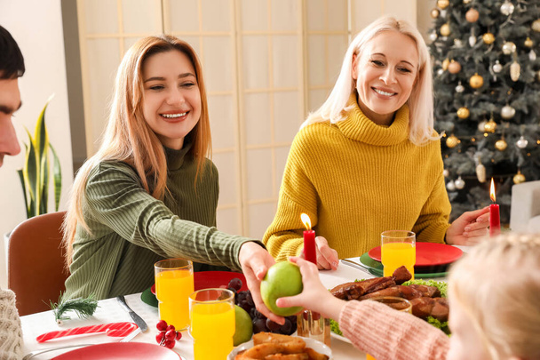 Jonge vrouw met familie diner thuis op kerstavond - Foto, afbeelding