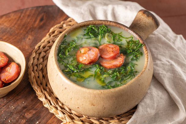 Caldo verde popularna zupa w kuchni portugalskiej. Tradycyjnymi składnikami caldo verde są ziemniaki, cebula, czosnek, zielenina collard, chorizo, oliwa z oliwek i sól. Jest to zupa komfort i jest zwykle podawany z chlebem kukurydzianym - Zdjęcie, obraz