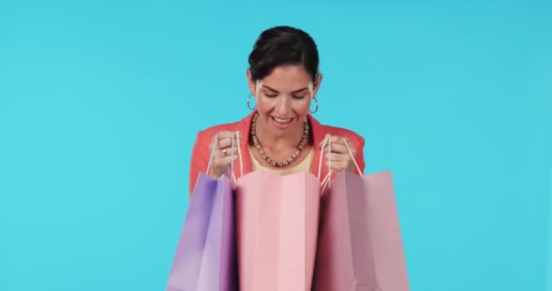 Wow, shopping bags or happy woman excited or surprised by prize in studio on blue background. Face portrait, smile or shocked girl with fashion gift or product on discount deals or promotional offer. - Footage, Video