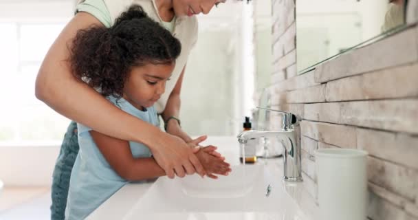 Aide, femme et enfant se lavent les mains dans la salle de bain, enseignement de l'hygiène et de la santé avec la routine de sécurité. Eau, savon et lavage des mains, apprentissage des soins de la peau par la mère et la fille, nettoyage de la saleté et des germes pour le bien-être. - Séquence, vidéo