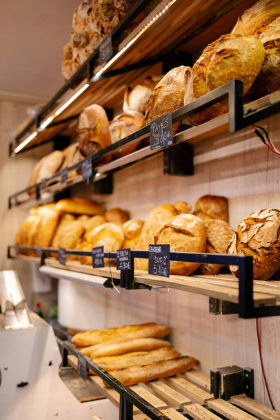 Hyllyn muotokuva, jossa on suuri joukko erilaisia leipiä leipomossa - Valokuva, kuva