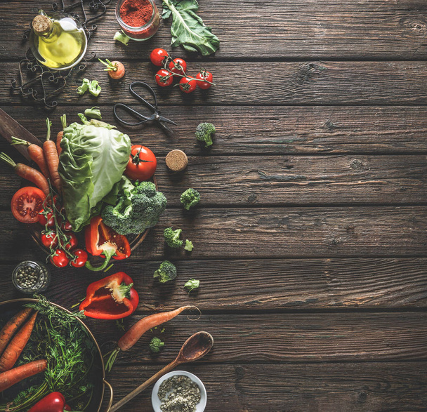 Voedselachtergrond met biologische groenten, gezonde ingrediënten en keukengerei op donker rustieke houten tafel. Bovenaanzicht. Kopieerruimte. - Foto, afbeelding