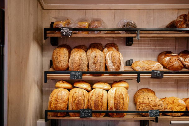 Porträt eines Regals mit einer großen Menge verschiedener Brote in einer Bäckerei - Foto, Bild