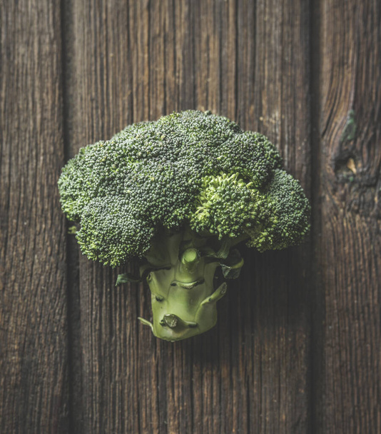 El primer plano del brócoli verde entero al fondo marrón rústico de madera. Vegetales orgánicos. Estilo de vida saludable. Vista superior. - Foto, Imagen