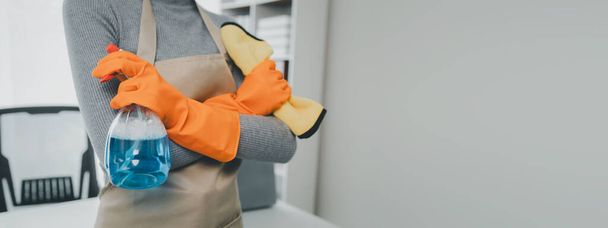Nosić fartuch i rękawice gumowe w celu ochrony przed chemikaliami czyszczącymi, Woźny czyszczenia biura, Użyj ręcznika, aby wytrzeć stół, Nosić rękawice gumowe podczas pracy z chemikaliami czyszczącymi, - Zdjęcie, obraz