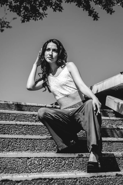 Beauty and latino charm: beautiful brunette model with a fashion look in a sunny day in the park (in black and white) - Foto, Bild