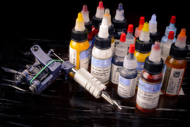 Dövme makinesi siyah izole birçok renk mürekkep şişeleri ile - Fotoğraf, Görsel