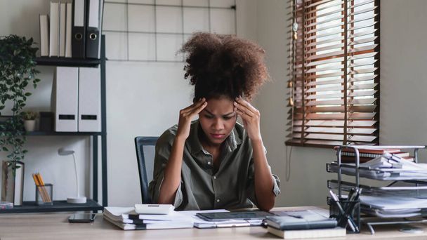 Afro-Amerikalı iş kadını baş ağrısı ve stres tabletteki finans verilerini okurken. - Fotoğraf, Görsel