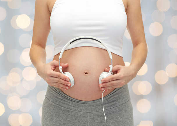 close up of pregnant woman and headphones on tummy - Fotografie, Obrázek