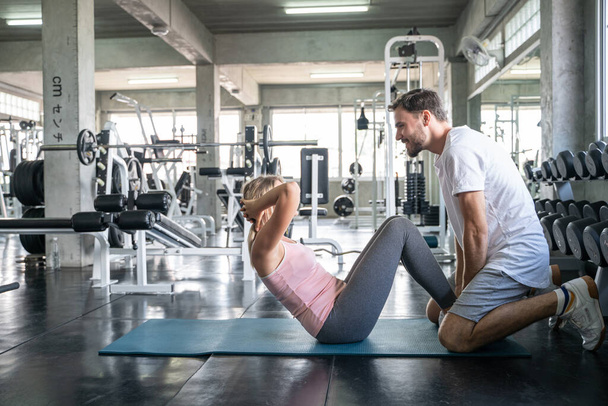 Sportpaar sitzt zusammen in Fitnessstudio Mann und Frau turnen zusammen - Foto, Bild
