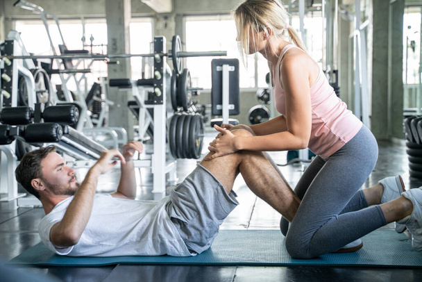 Sport couple sit up together in fitness gym man and woman exercise together - Photo, Image