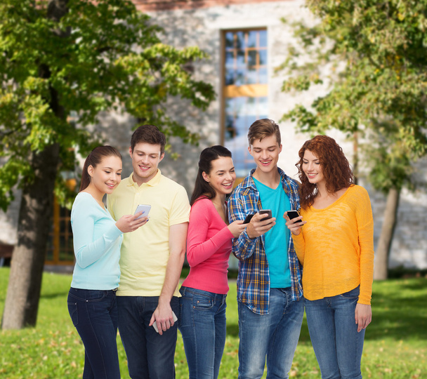Grupa nastolatków uśmiechający się ze smartfonów - Zdjęcie, obraz