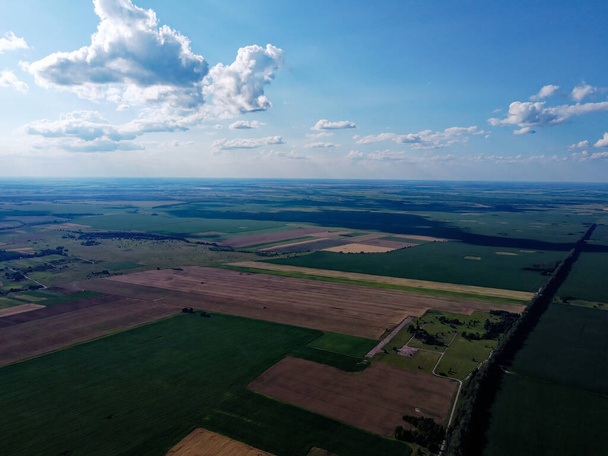 Prachtig landbouwlandschap, open veld met blauwe lucht en witte wolken. Boerderijen vanuit vogelperspectief. - Foto, afbeelding