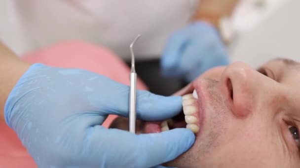 man dentist. Reception at the orthodontist. Polishing. Gel bonding. - Footage, Video