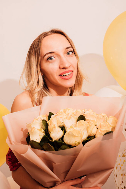 Молода приваблива жінка в довгій сукні з трояндами та повітряними кульками. Вечірка, святкування. Високоякісна фотографія - Фото, зображення