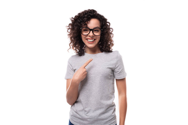giovane donna riccia brunetta sorridente vestita con una t-shirt basic grigia con stampa space loy su tessuto. - Foto, immagini