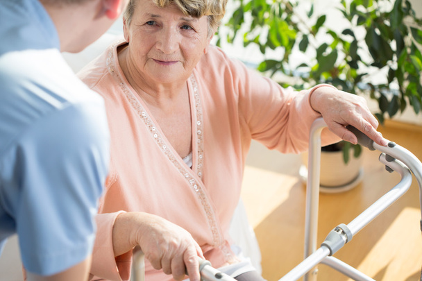 Nurse assisting disabled pensioner - Фото, изображение