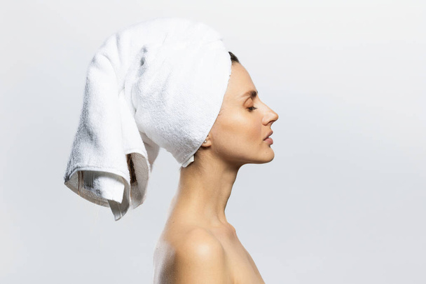 Mulher bonita e sexy usando toalha branca na cabeça. Sensualidade, bem-estar e conceito de spa. - Foto, Imagem